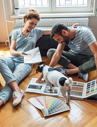 couple looking at paint swatches with dog
