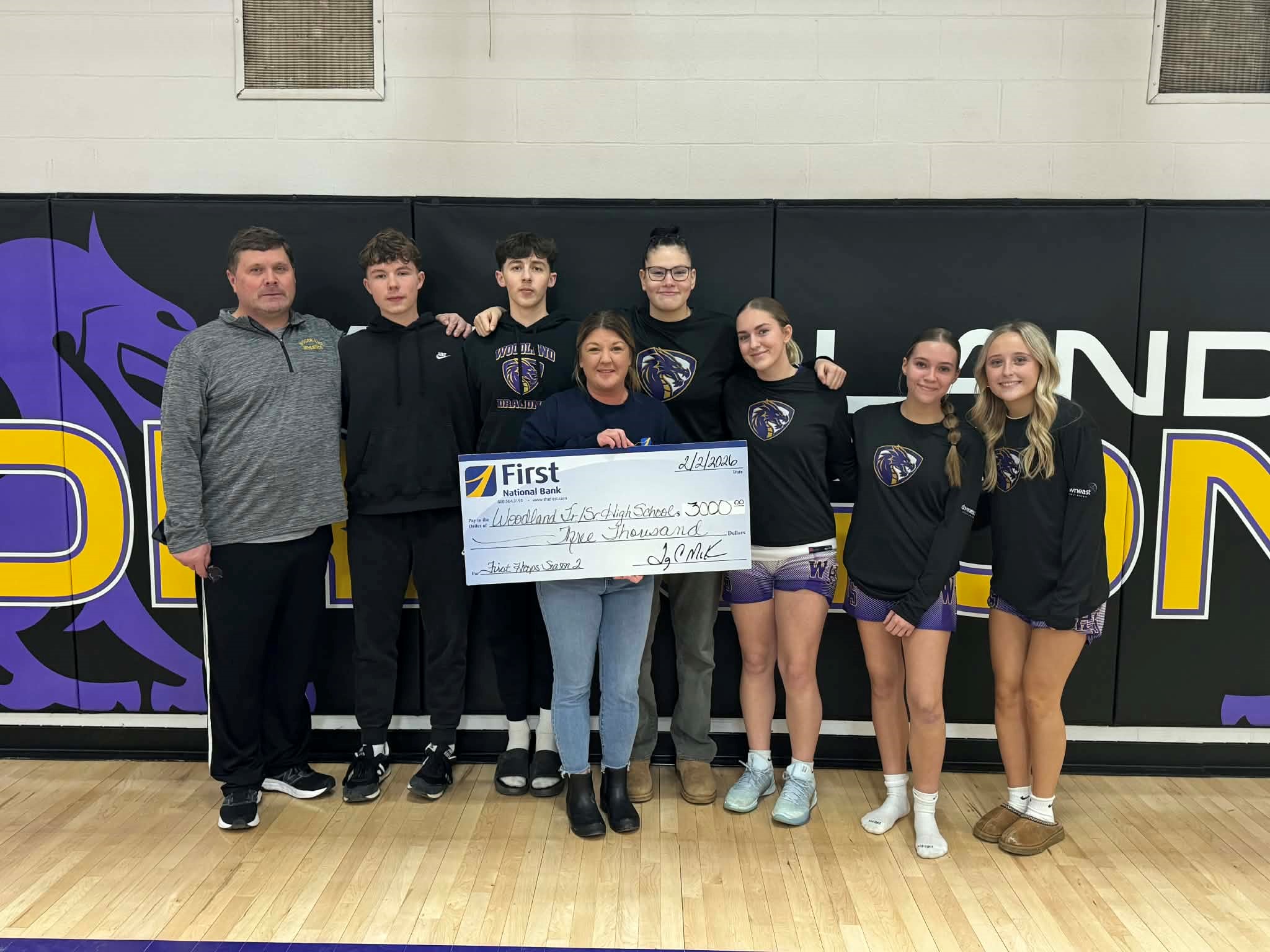 Community members posing for a check presentation photo.